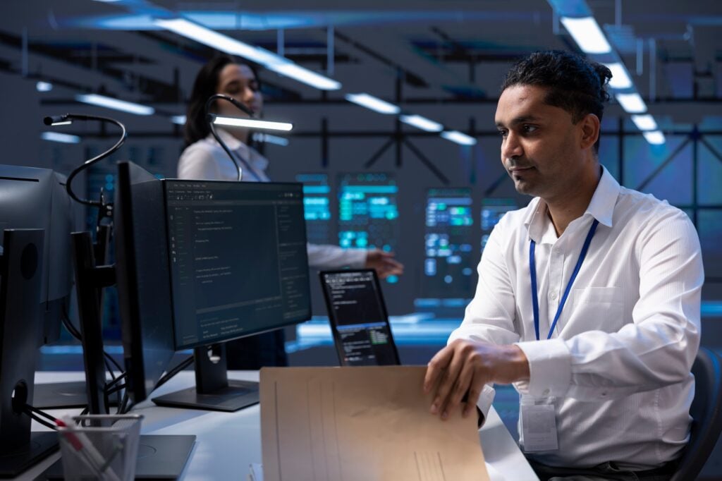 Man in server room ensuring compliance with industry regulations