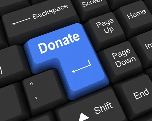 An image of a keyboard featuring a prominently displayed blue button with the word 'donate' written on it.